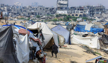 Displaced Palestinians shelter in a tent camp as buildings damaged during the Israeli offensive in Gaza. (REUTERS)